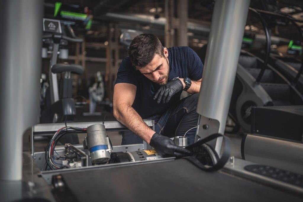 Tecnico specializzato durante la manutenzione di un’attrezzatura fitness